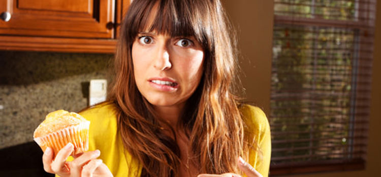 woman-wondering-whether-to-eat-muffin